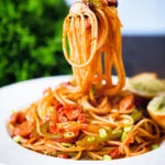 Spaghetti napolitan a Japanese tomato ketchup pasta with sausage and bacon being eaten with a fork.