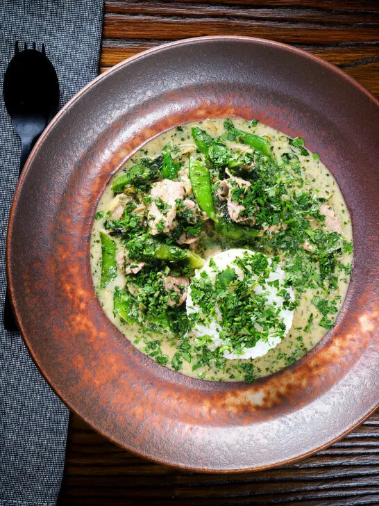 Overhead herby Thai green pork curry with sugar snap peas and jasmine rice.