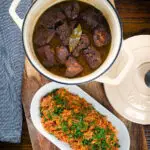 Overhead Afelia or Cypriot pork braised in red wine and coriander seeds in a cooking pot served with pourgouri.