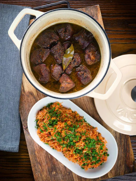 Overhead Afelia or Cypriot pork braised in red wine and coriander seeds in a cooking pot served with pourgouri.