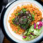Overhead Afelia or Cypriot pork braised in red wine and coriander seeds with pourgouri.