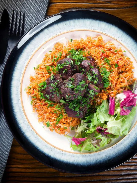 Overhead Afelia or Cypriot pork braised in red wine and coriander seeds with pourgouri.