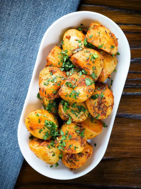 Overhead aloo jeera (Indian spiced cumin potatoes) garnished with fresh coriander.
