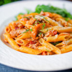 BBQ chicken and bacon pasta with cheddar cheese served with rocket.