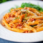 BBQ chicken and bacon pasta with cheddar cheese served with rocket.