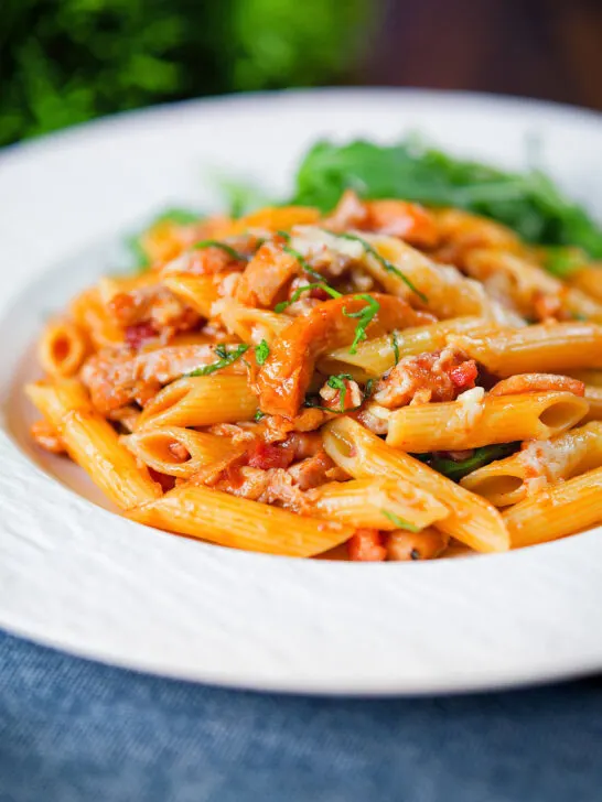 BBQ chicken and bacon pasta with cheddar cheese served with rocket.