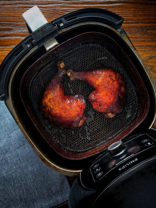 Char siu chicken legs in an air fryer basket.