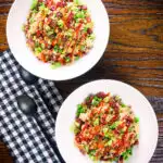 Overhead Chinese sausage (lap cheong) and egg fried rice with garden peas and spring onion.
