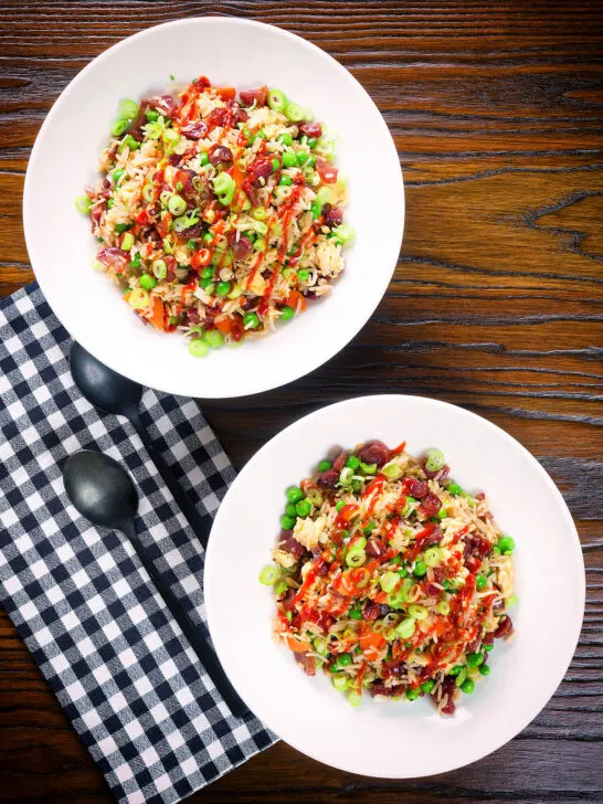 Overhead Chinese sausage (lap cheong) and egg fried rice with garden peas and spring onion.