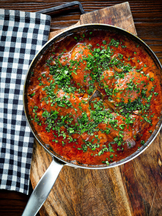 Overhead Goan chicken xacuti curry served in a cooking pan.