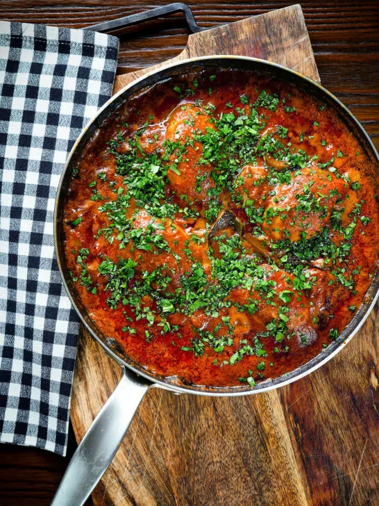 Overhead Goan chicken xacuti curry served in a cooking pan.