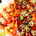 Overhead close-up gochujang and honey glazed salmon fillet served with kimchi and rice.