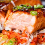 Close-up gochujang and honey glazed salmon fillet cut open to show cooked texture.