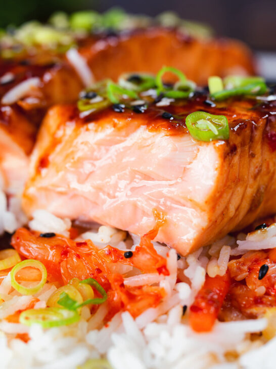 Close-up gochujang and honey glazed salmon fillet cut open to show cooked texture.