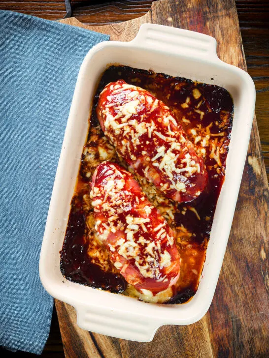 Overhead British hunters chicken stuffed with cheddar cheese, wrapped in bacon and cooked in BBQ sauce.