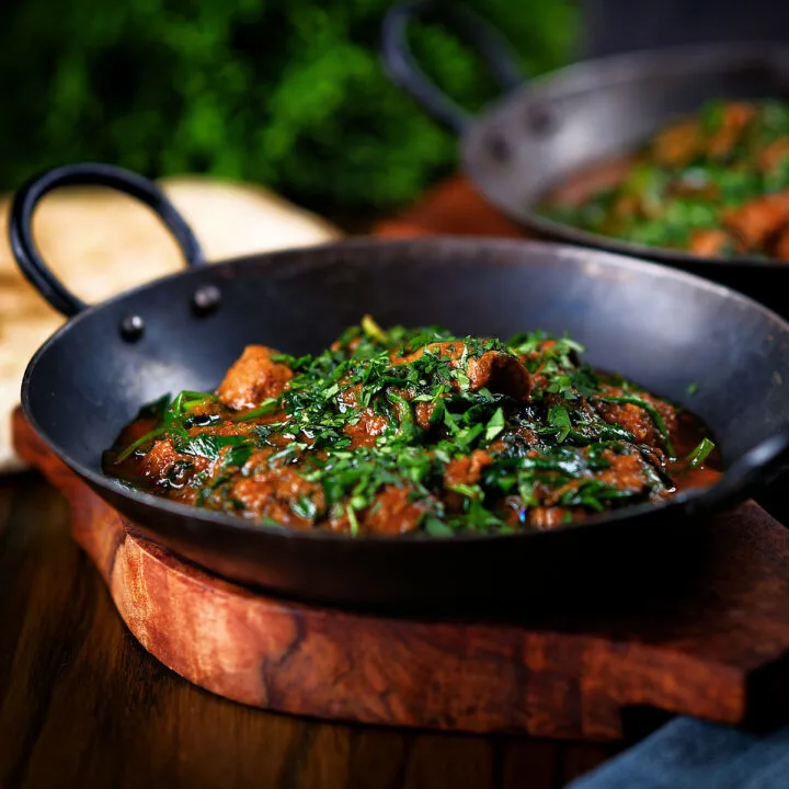 Lamb saag or saagwala (lamb and spinach curry) served with naan bread and fresh coriander.
