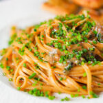 Miso butter pasta with pecorino, black & pink peppercorns and chives served with garlic bread.