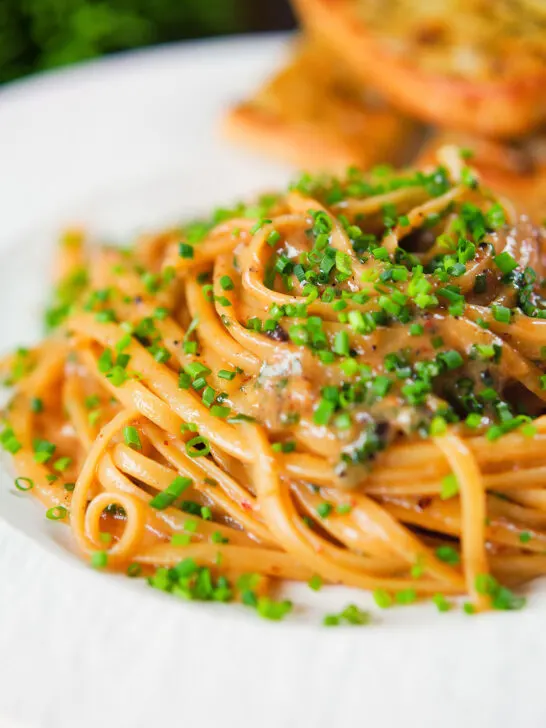 Miso butter pasta with pecorino, black & pink peppercorns and chives served with garlic bread.