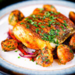 Pan fried curried cod fillet with cumin potatoes and tomato & onion salad.
