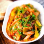 Basque piperade a pepper, onion and tomato stew garnished with parsley and served with bread.