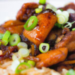 Close-up spicy Shanghai chicken stir fry served with egg fried rice.