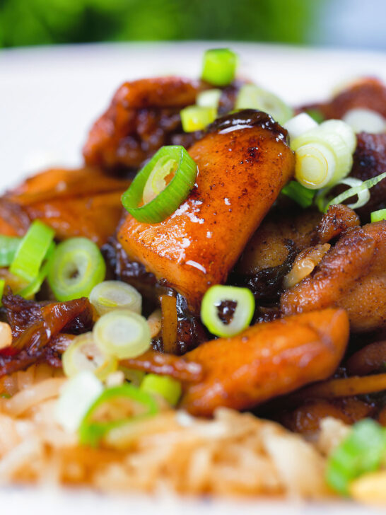 Close-up spicy Shanghai chicken stir fry served with egg fried rice.
