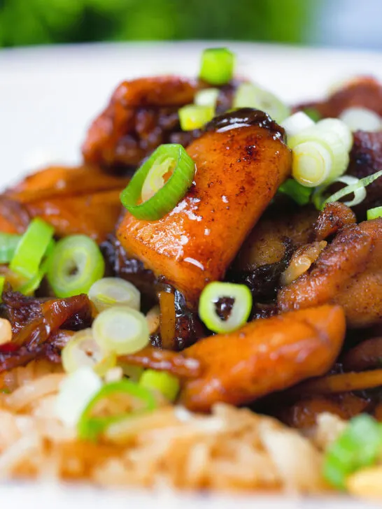 Close-up spicy Shanghai chicken stir fry served with egg fried rice.