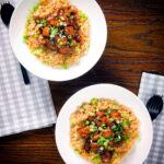 Overhead spicy Shanghai chicken stir fry served with egg fried rice.