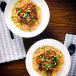 Overhead spicy Shanghai chicken stir fry served with egg fried rice.