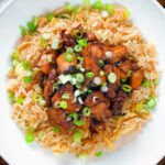 Close-up overhead spicy Shanghai chicken stir fry served with egg fried rice.