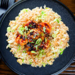 Overhead teriyaki king prawns (shrimp) stir fry served with egg fried rice.