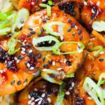 Close-up overhead teriyaki king prawns (shrimp) stir fry served with egg fried rice.