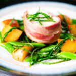 Bacon wrapped monkfish with potatoes, samphire and sugar snap peas in butter and cider.