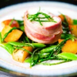 Bacon wrapped monkfish with potatoes, samphire and sugar snap peas in butter and cider.