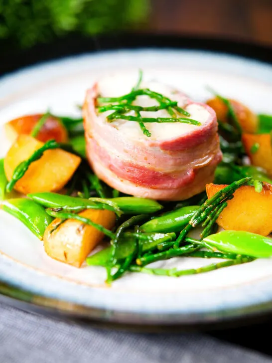 Bacon wrapped monkfish with potatoes, samphire and sugar snap peas in butter and cider.