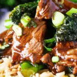 Close up beef and broccoli stir fry garnished with spring onions.