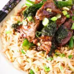 Close up beef and broccoli stir fry served with egg fried rice.