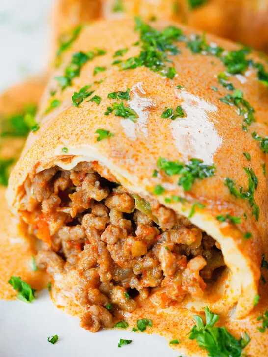 Close-up Hortobágyi palacsinta Hungarian meat stuffed pancakes in a sour cream and paprika sauce.