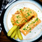 Overhead Hortobágyi palacsinta Hungarian meat stuffed pancakes in a sour cream and paprika sauce.