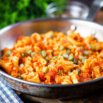 Hungarian potato and paprika pasta (Krumplis Teszta) with pickles in a cooking pan.