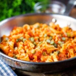 Hungarian potato and paprika pasta (Krumplis Teszta) with pickles in a cooking pan.