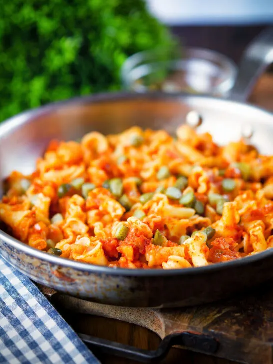 Hungarian potato and paprika pasta (Krumplis Teszta) with pickles in a cooking pan.