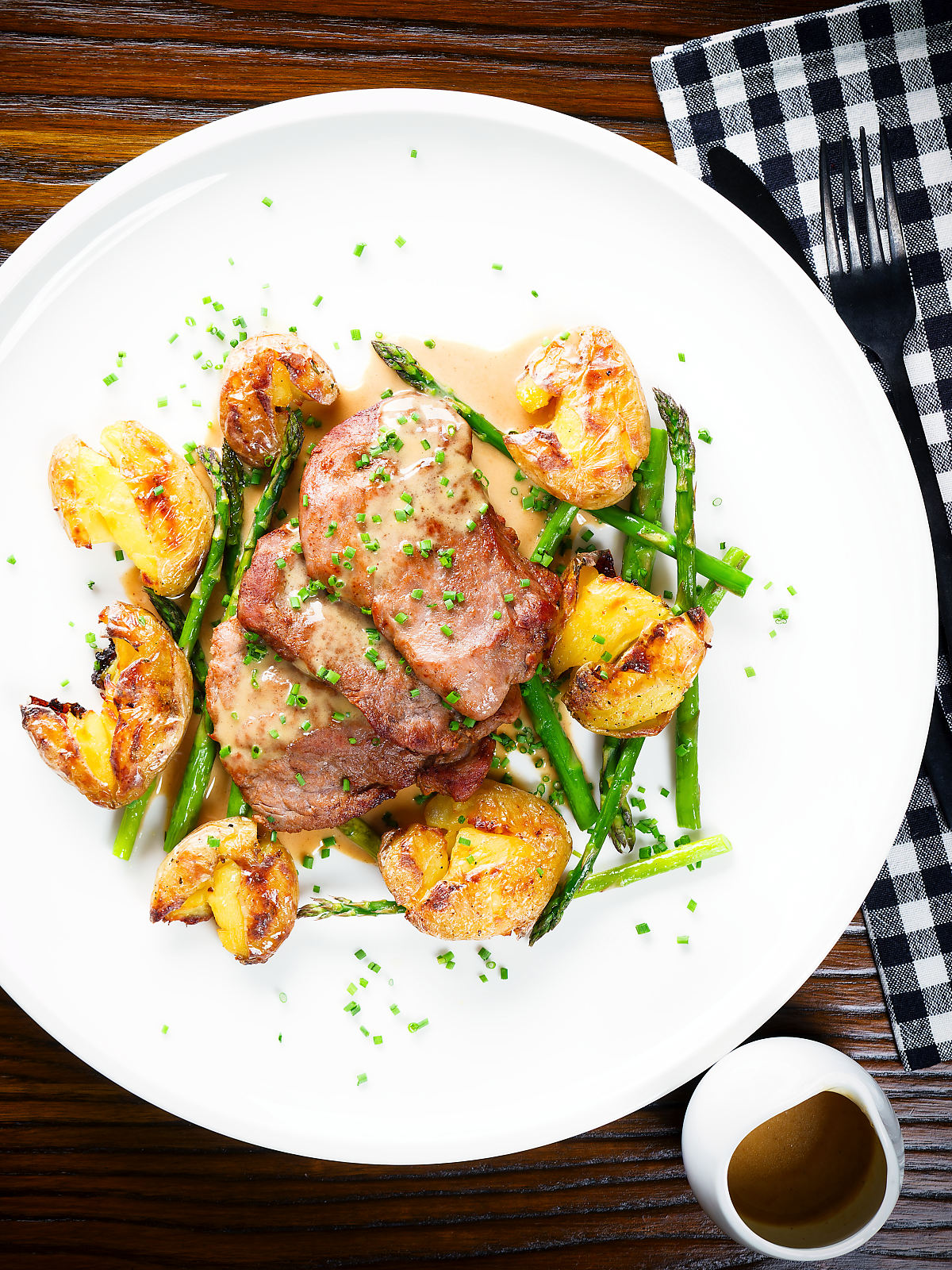 Overhead pork tenderloin medallions with a cider, mustard and camembert sauce, new potatoes and asparagus.