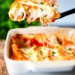 Baked three cheese pork sausage, leek and ricotta stuffed cannelloni being served.