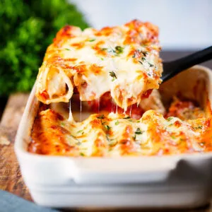 Baked cheesy pork sausage, leek and ricotta stuffed cannelloni being served.
