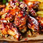 Sticky teriyaki chicken wings with, chilli, spring onions, sesame seeds and French fries.