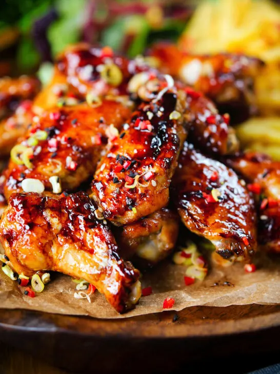 Sticky teriyaki chicken wings with, chilli, spring onions, sesame seeds and French fries.
