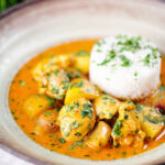 Thai yellow chicken curry with new potatoes, shallots and steamed jasmine rice garnished with coriander.