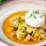 Thai yellow chicken curry with new potatoes, shallots and steamed jasmine rice garnished with coriander.