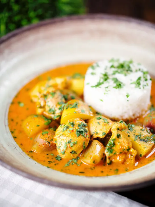 Thai yellow chicken curry with new potatoes, shallots and steamed jasmine rice garnished with coriander.